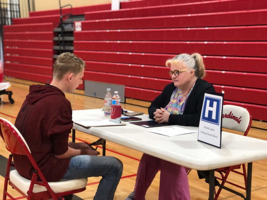 Nurse Laura assists a student during the 8th Grade Reality Maze Spring 2022.