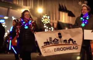 Jen Wichita holds a Better Brodhead banner while walking in the 2017 Brodhead Fire and Ice parade.